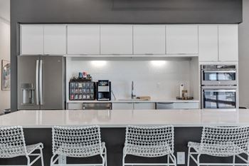 a large white kitchen with a counter and chairs